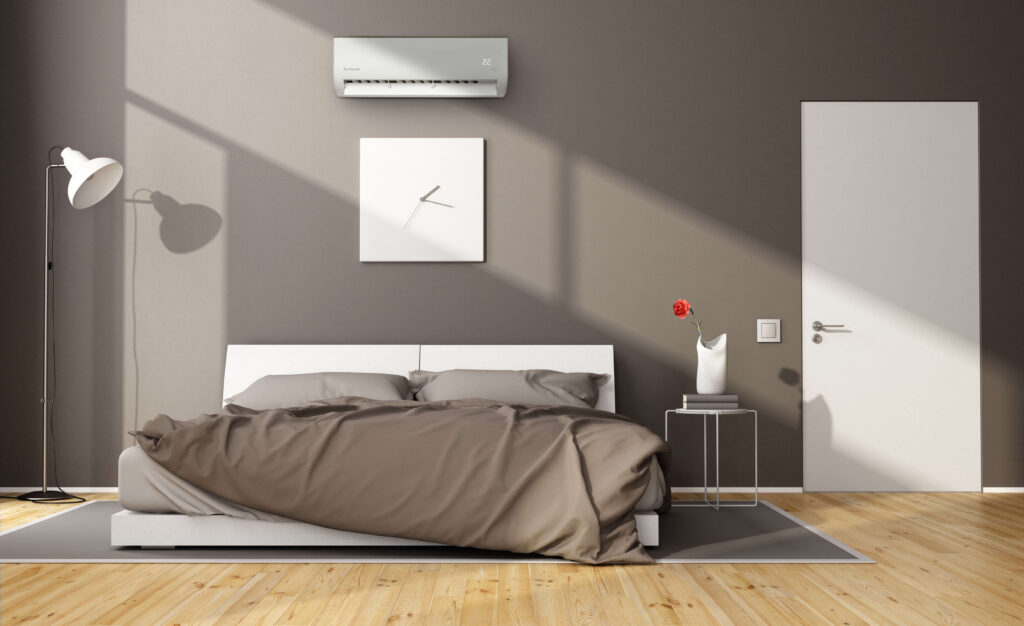 Minimalist bedroom with a double bed, gray bedding, and a wall-mounted air conditioner